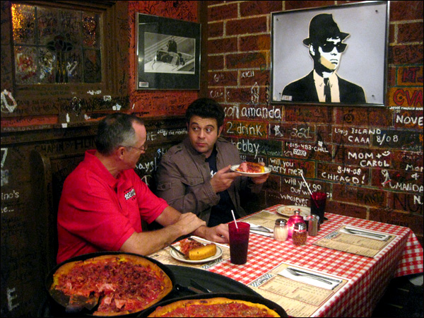 two men eating big pizzas