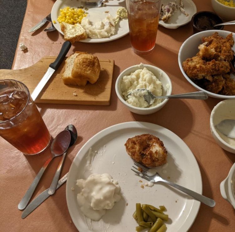 glass of sweet, iced tea, plate of fried chicken and sides